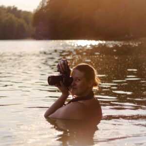 ciałożyczliwa fotografka podczas sesji zdjęciowej w jeziorze