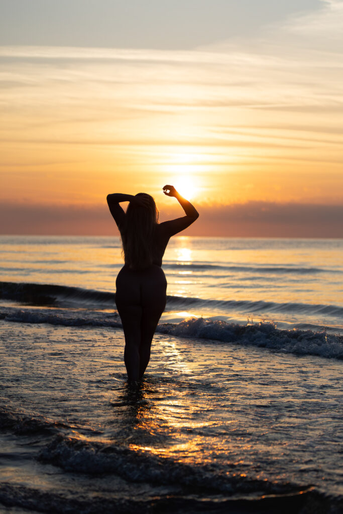 sesja nagości nad morzem o zachodzie słońca