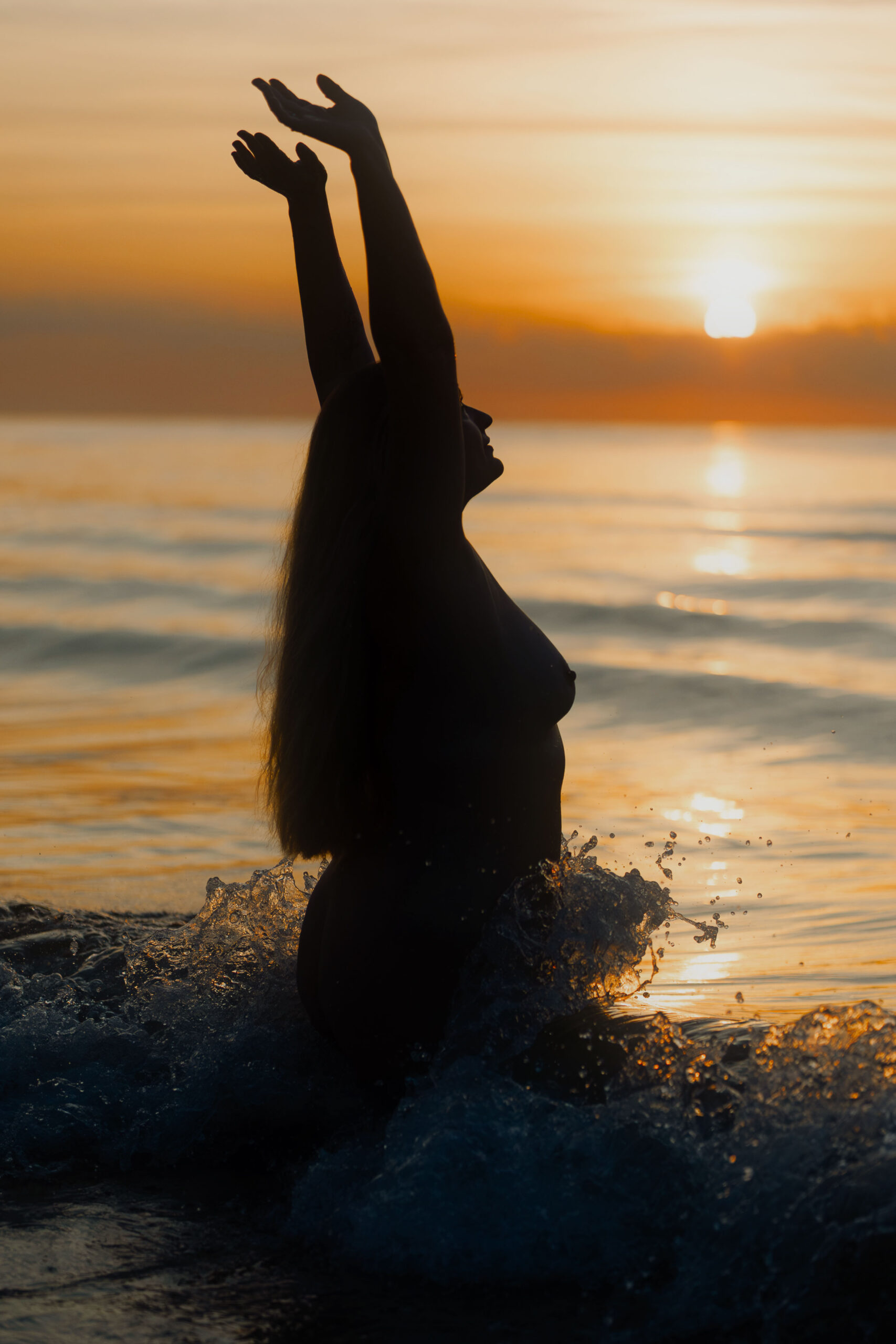 sesja nagości nad morzem o zachodzie słońca